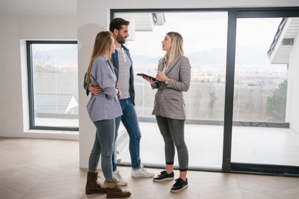 Urban planning in Victoria has seen a lot of changes over the last 10 to 15 years, particularly in terms of lot sizes. Image of couple talking to female property expert in an empty apartment. 